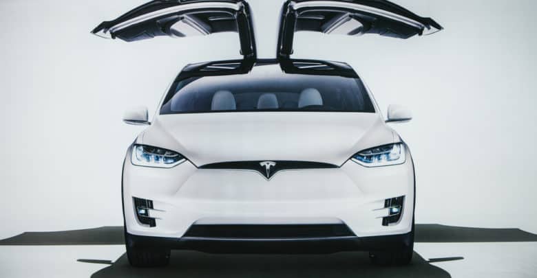 רכב חשמלי מסוג טסלה מודל X בצבע לבן עם דלתות פתוחות