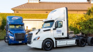 שתי משאיות סמי טריילר חשמליות ללא מטען של חברת דיימלר, אחת בצבע לבן ואחת בצבע כחול