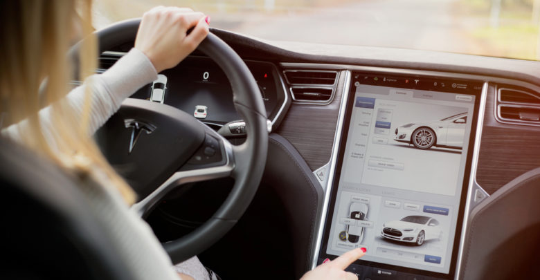 אישה מפעילה את מערכת המולטימדיה ברכב מסוג טסלה מודל S