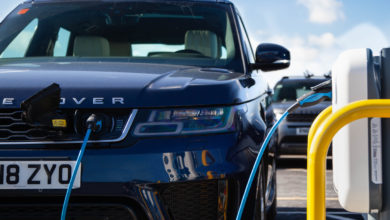 רכב של חברת לנד-רובר בצבע כחול מחובר לעמדת טעינה