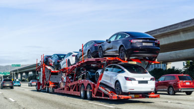 מובילית רכב אדומה עם רכבי טסלה מודל 3 חדשים על כביש מהיר בסן פרנסיסקו