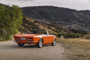 פיאט 124 בצבע כתום אדום שהוסבה להנעה חשמלית עומדת בטבע