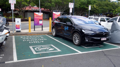 טסלה מודל X בצבע שחור נמצאת בעמדת טעינה כפולה מסומנת בחניה באוסטרליה