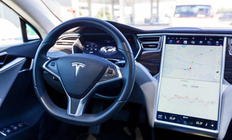 פנים של רכב מסוג טסלה מודל X עם מבט לעבר ההגה ומסך מגע גדול המציג מפה
