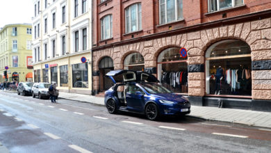 טסלה מודל X כחולה עם דלתות אחוריות פתוחות ברחוב בעיר אוסלו נורווגיה