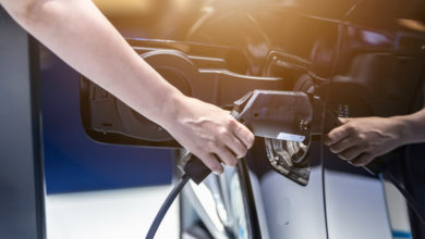 אדם מחבר רכב חשמלי לטעינה