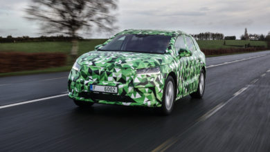 סקודה ENYAQ iV עטופה בכיסוי ירוק נוסעת על כביש בין עירוני