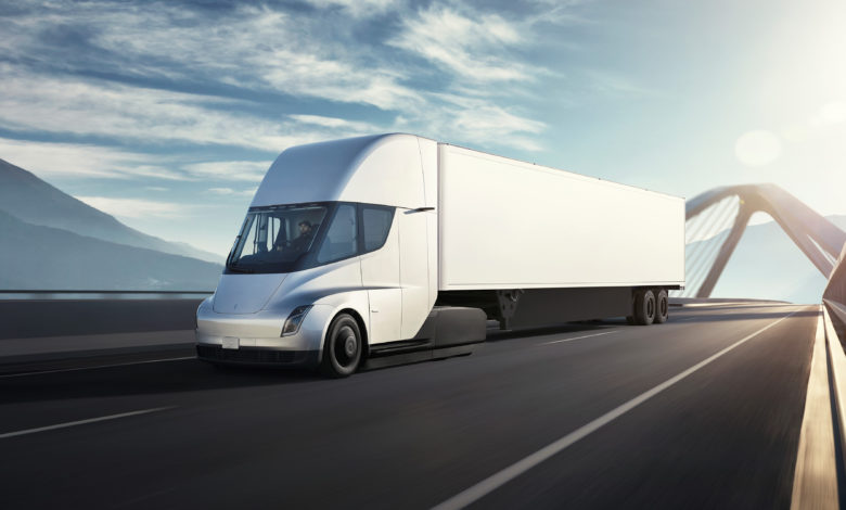 משאית לבנה מסוג טסלה סמי נוסעת על גשר