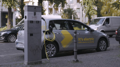 פולקסווגן גולף חשמלית של WeShare חונה ברחוב בברלין ומחוברת לעמדת טעינה