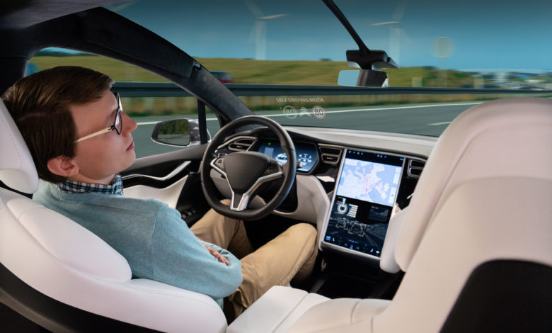 אדם במושב הנהג של טסלה כשהאוטופיילוט של הרכב מנווט את הרכב