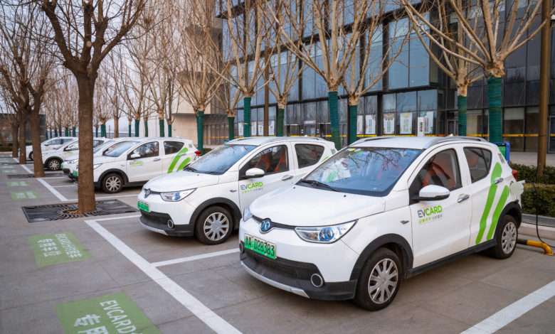 רכבים חשמליים קומפקטיים בחניות מיועדות לרכבים חשמליים ומחוברים לעמדת טעינה בסין