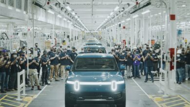 הרכבים הראשונים של ריביאן יוצאים מהמפעל עם העובדים מסביב הרכבים בהתרגשות