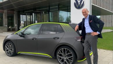 ראלף ברנדשטטר, מנהל מותג פולקסווגן, עומד ליד רכב חשמלי פולקסווגן ID.X בצבע אפור