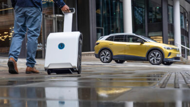 אדם סוחב את המטען של ZipCharge גו והולך אל עבר פולקסווגן ID.4 עם המטען הנייד