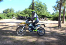 אופנוע חשמלי סורון לייט בי בנסיעה בשטח עם עשרות אופנועים מאחוריו רחוק