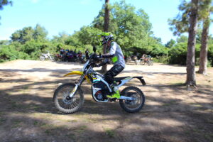 אופנוע חשמלי סורון לייט בי בנסיעה בשטח עם עשרות אופנועים מאחוריו רחוק