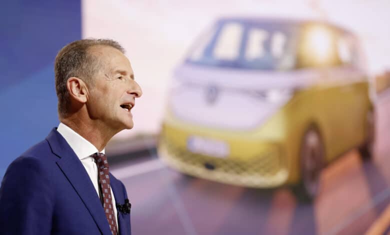 מנכ״ל פולקסווגן הרברט דיס עם תמונה של פולקסווגן ID Buzz מאחוריו