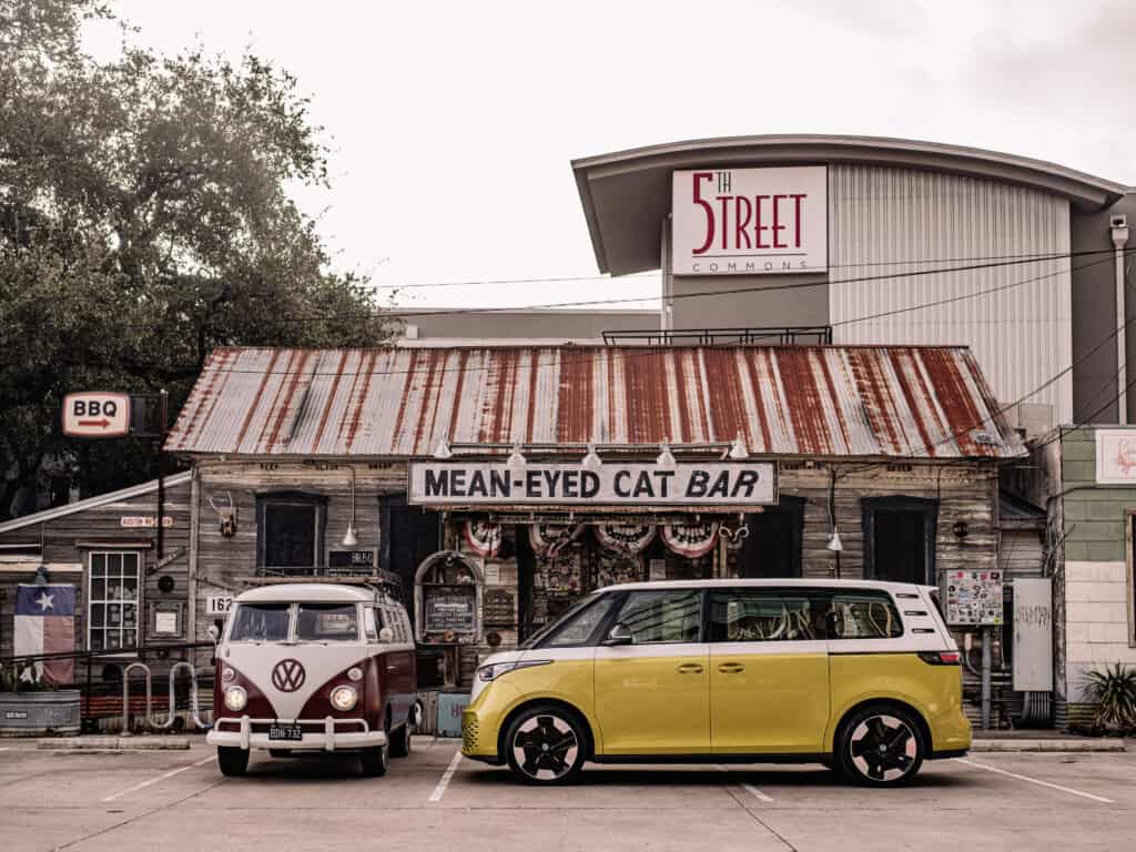 פולקסווגן ID Buzz חשמלי בצבע כתום עומד לצד פולקסווגן טייפ1 