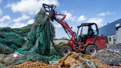 טרקטור אדום אוסף רשתות דיג ישנות מעריכה של רשתות דיג המיועדות למחזור