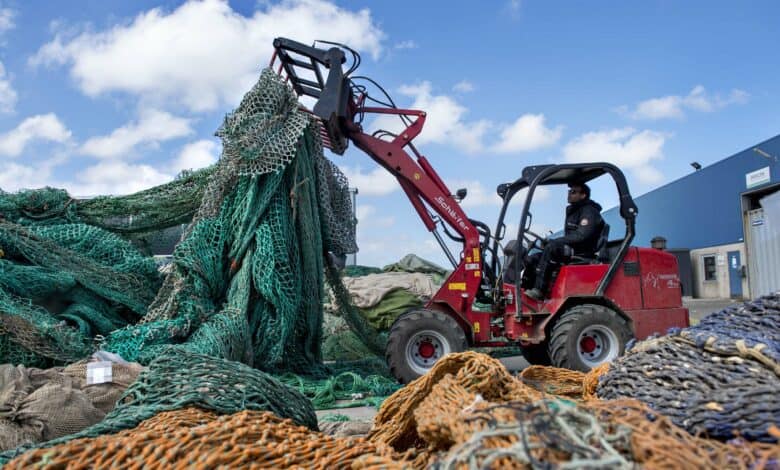 טרקטור אדום אוסף רשתות דיג ישנות מעריכה של רשתות דיג המיועדות למחזור