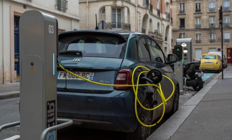 פיאט e500 חשמלית חונה ומחוברת לעמדת טעינה ברחוב בפריז, צרפת
