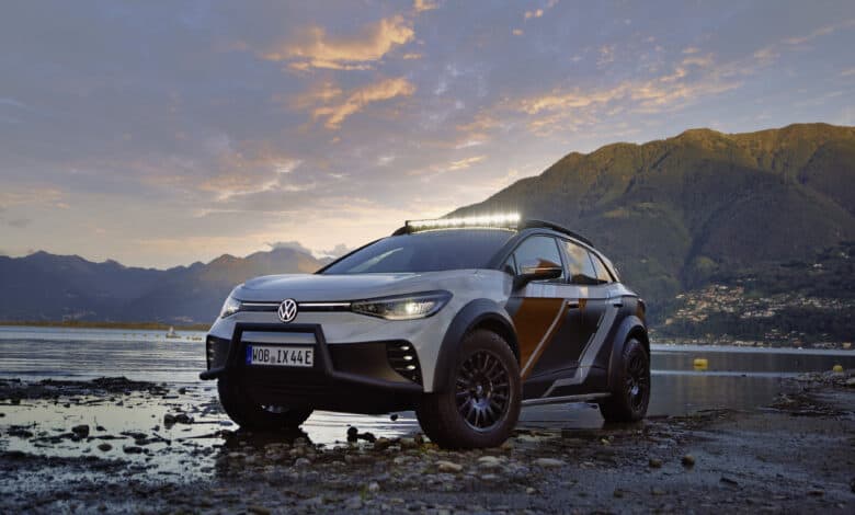 פולקסווגן ID. EXTREME רכב שטח חשמלי עומד במים רדודים ליד אגם