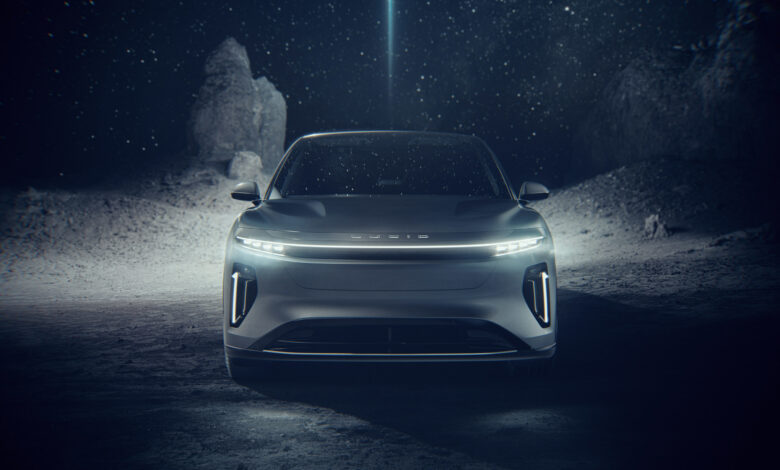 רכב הפנאי החשמלי היוקרתי לוסיד גרביטי במבט מקדימה עם פס לד קדמי שנמתח לאורך הרכב, שנמצא על כוכב לכת או ירח בחלל