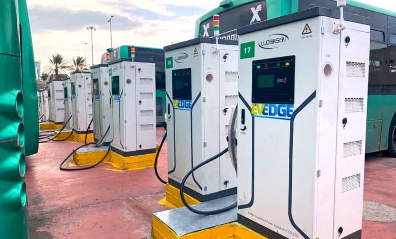 שורה של עמדות טעינה מהירות לאוטבוסים של חברת EV-Edge עם אוטבוסים ירוקים של אגד ליד העמדות