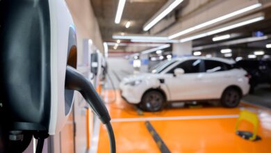 שורה של חניות צבועות בכתום מצוידות בעמדות טעינה רגילות לרכב חשמלי