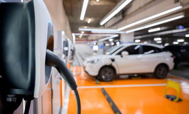 שורה של חניות צבועות בכתום מצוידות בעמדות טעינה רגילות לרכב חשמלי