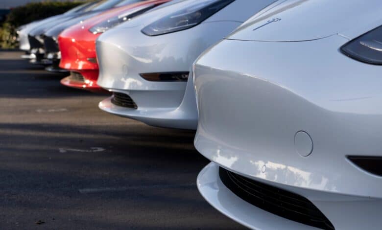 החלק הקדמי של מספר רכבי טסלה מודל 3 בצבעים שונים עומדים זה לצד זה