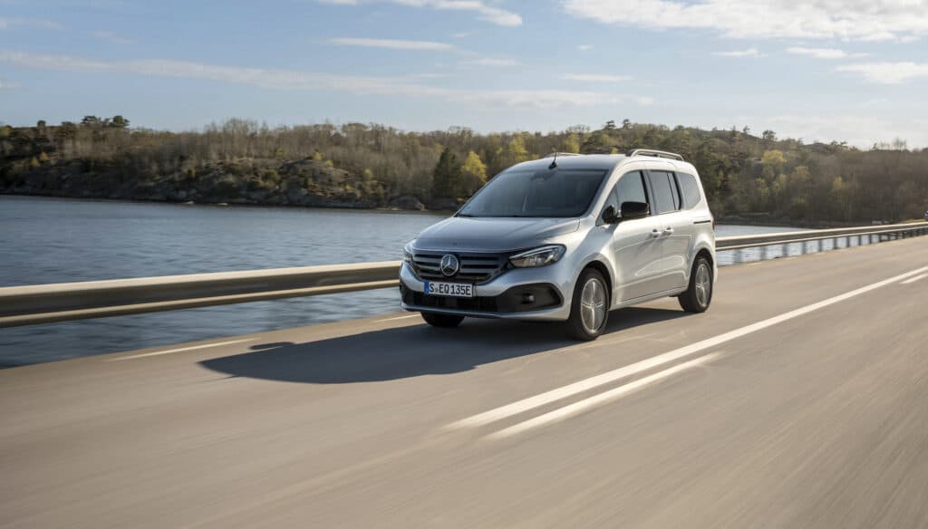 מיניוואן חשמלי מרצדס EQT בנסיעה על גשר מעל אגם