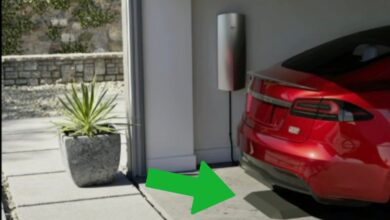 מכשיר רצפתי הנראה כמטען אלחוטי כשמעליו טסלה מודל S אדומה