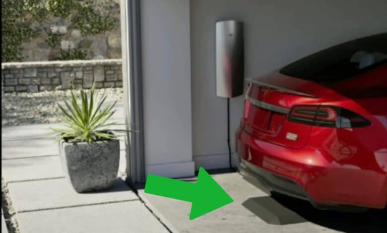 מכשיר רצפתי הנראה כמטען אלחוטי כשמעליו טסלה מודל S אדומה