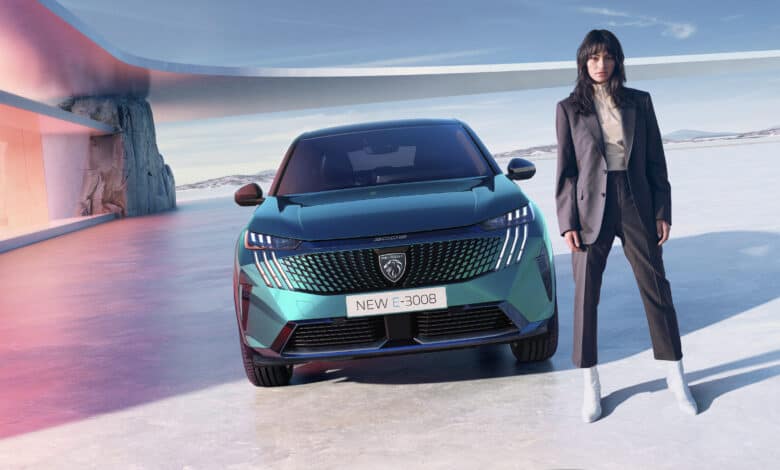 אישה עומדת לצד פיג׳ו E-3008 החשמלית החדשה