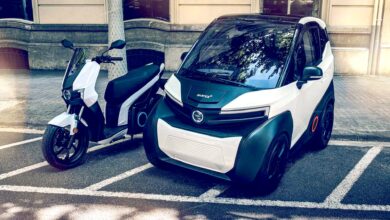 רכב מיקרו חשמלי סיילנס 04 לצד קטנוע חשמלי בעיר