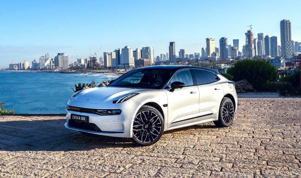 זיקר 001 חשמלי בתל אביב על רקע קו הרקיע של תל אביב