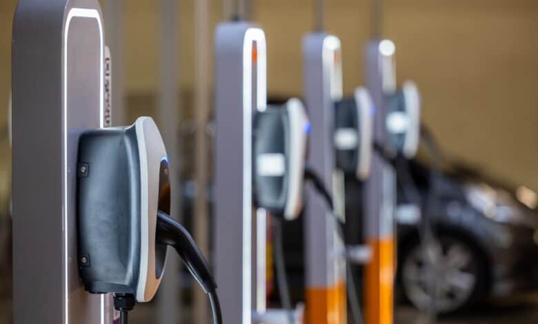 מספר עמדות טעינה לרכב חשמלי מותקנות על עמוד ומוצבות זו לצד זו בחניון ציבורי