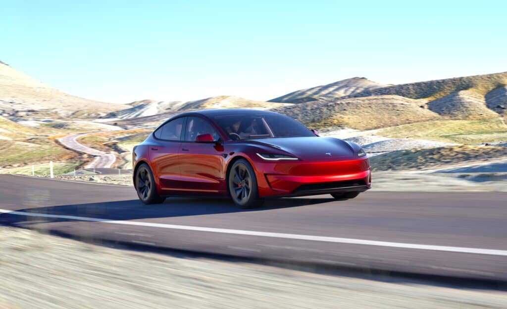 טסלה מודל 3 פרפורמנס גרסת ביצועים 2024 בצבע אדום בנסיעה על כביש במהירות גבוהה