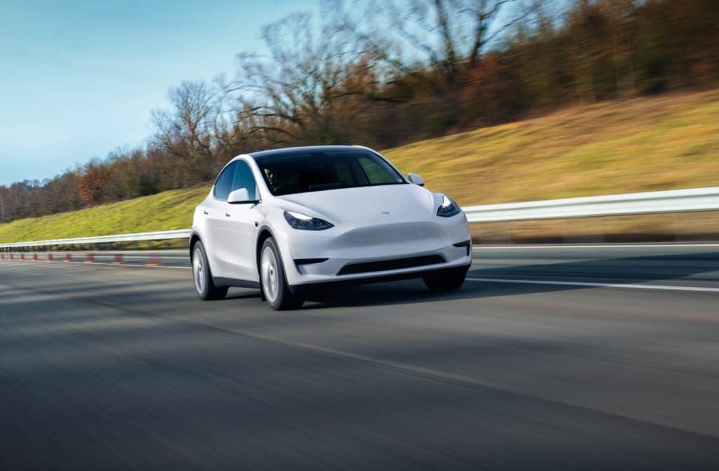 טסלה מודל Y בצבע לבן בנסיעה על כביש בינעירוני