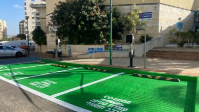 עמדות טעינה איטיות לרכב חשמלי במתחם של אזורים עם חניות מסומנות בירוק