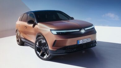 מבט קדמי על אופל גרנדלנד חשמלי עם לוגו מואר של אופל במרכזו ושני פסי לד נמתחים מהתאורה הקדמית אל כיוון הלוגו