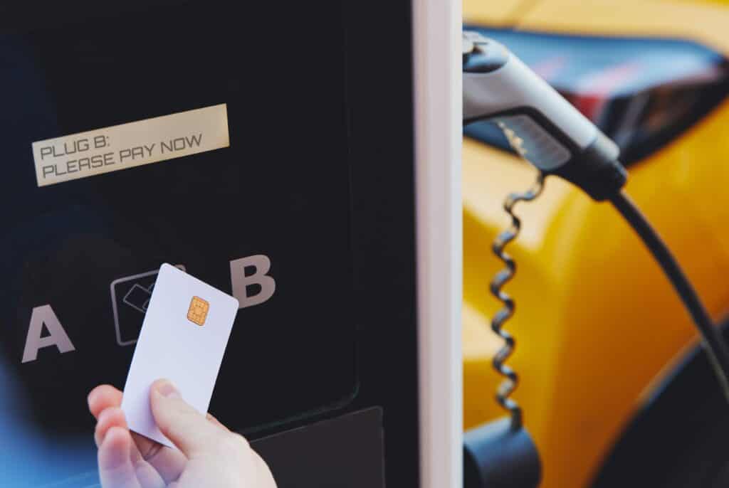 אדם מצמיד כרטיס אשראי לעמדת טעינה לצורך תשלום