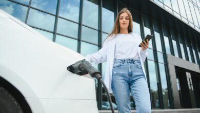 אישה מטעינה רכב חשמלי