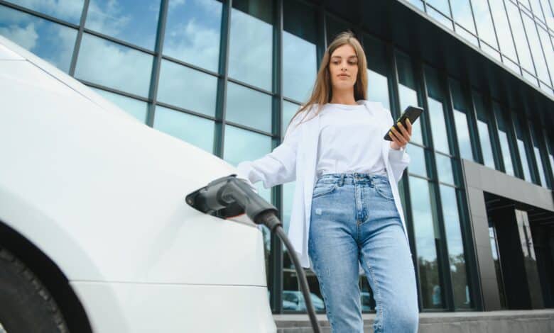 אישה מטעינה רכב חשמלי