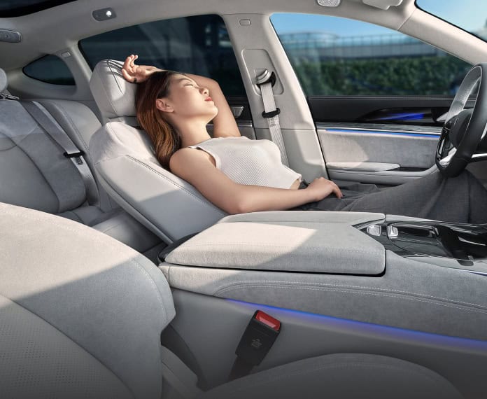 נהגת יושבת בתא הנהג ומתרווחת לאחור ברכב החשמלי נטע S