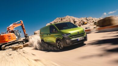 פולקסווגן טרנספורטר חשמלי בשטח עם מחפר מאחוריו