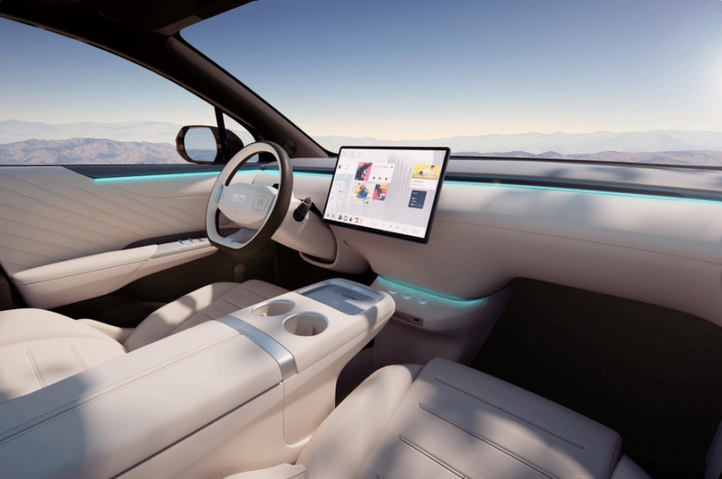 סביבת הנהג בניבו E07 מעוצבת בצורה מינימליסטית, עם ריפוד וחיפויים לבנים ומסך מולטימדיה במרכז הרכב