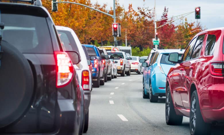 פקקים בכביש בעיר עמוסה עם רכבי בנזין, רכבים חשמליים ורכבים היברידים