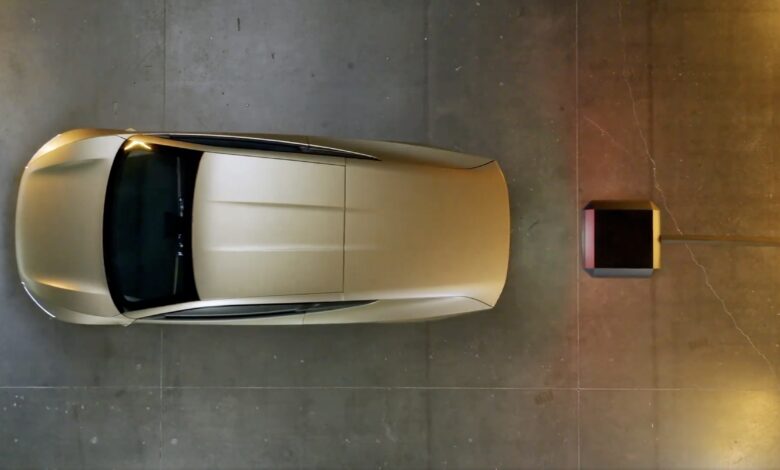 מבט מעל על טסלה סייברקאב זהובה מתקרבת למתקן עמדת טעינה אלחוטית לרכב חשמלי